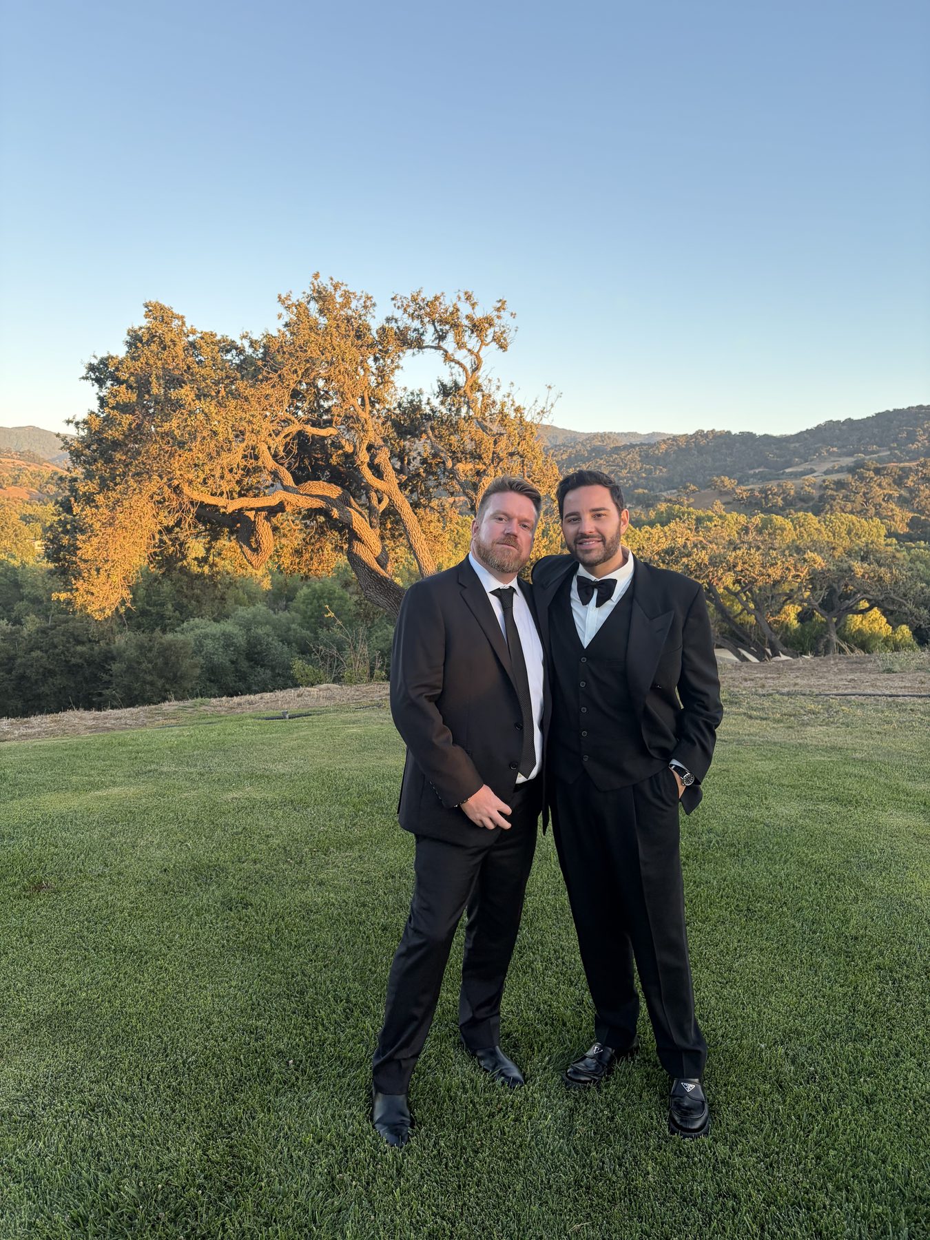 Jeff and Markus dressed formally outdoors at sunset