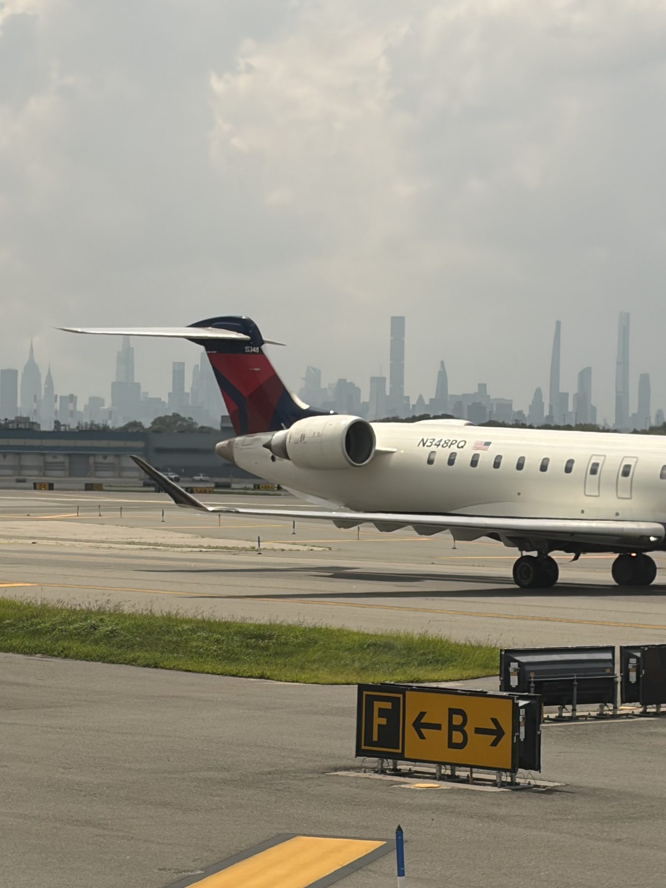 Airplane on a runway with a city skyline