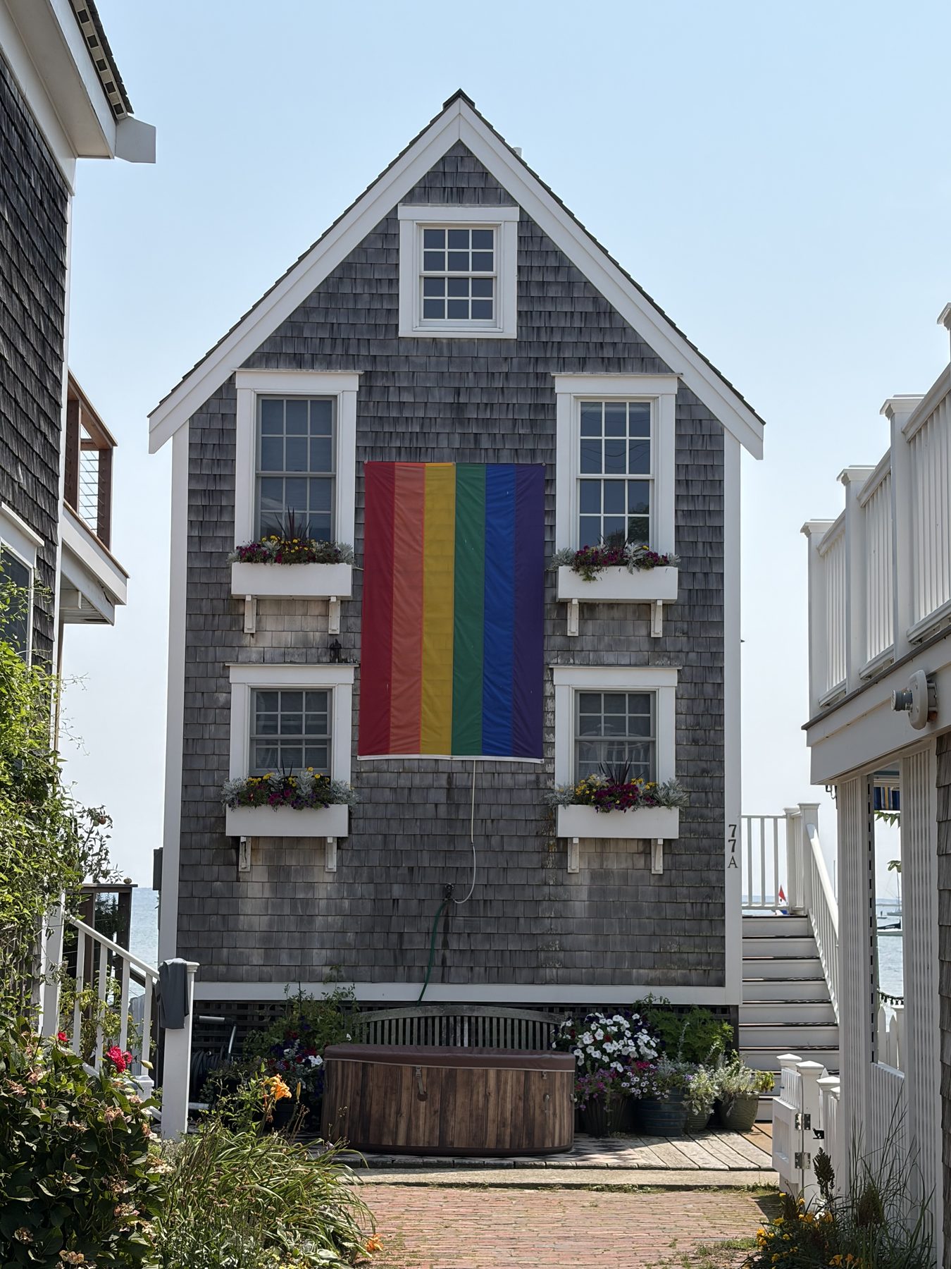 A coastal house displaying a large Pride flag